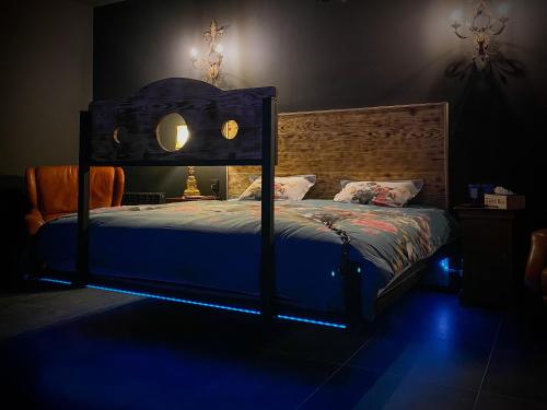 Un dormitorio con una cama con una luz azul. en Loveroom avec jacuzzi 01 en Chazey-sur-Ain