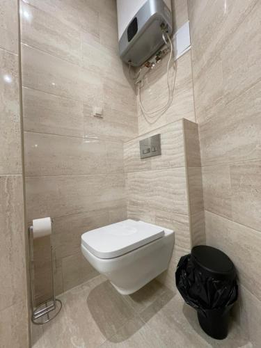 ein Badezimmer mit einem weißen WC und einem Mülleimer in der Unterkunft Revesen Premium Apartments in Krakau