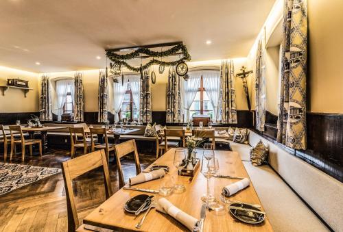 a restaurant with wooden tables and chairs and windows at Krone - das Gasthaus in Kirchhofen