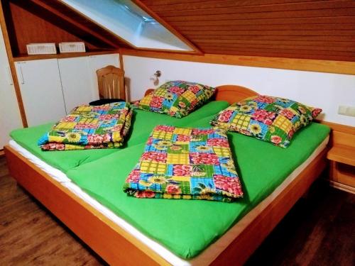 2 camas en una habitación con sábanas y almohadas verdes en Ferienwohnung Waldkäuzle27, en Lenzkirch