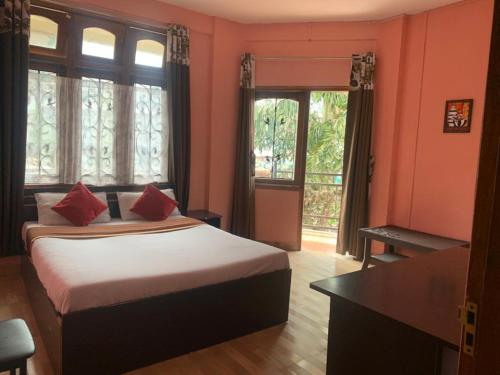 ein Schlafzimmer mit einem Bett mit roten Kissen darauf in der Unterkunft Stay Inn Belle Vue House in Shillong