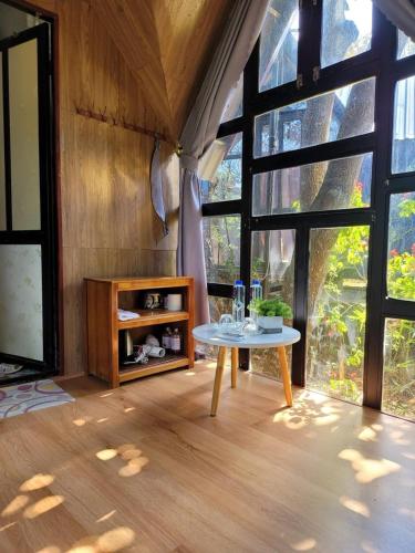 a room with a table and large windows at Homestay Bản Búa in Mộc Châu