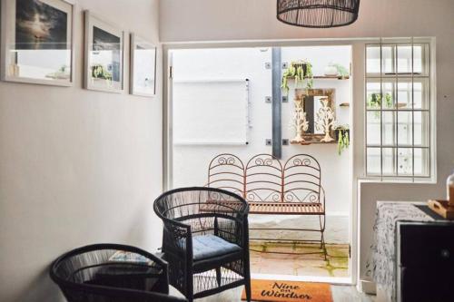 a living room with a chair and a window at Cottage, Nine on Windsor, Kalk Bay, Cape Town in Kalk Bay