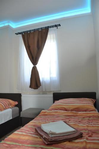 a bedroom with a bed and a window with a curtain at Aba-Böbe Vendégház in Zalaszentiván