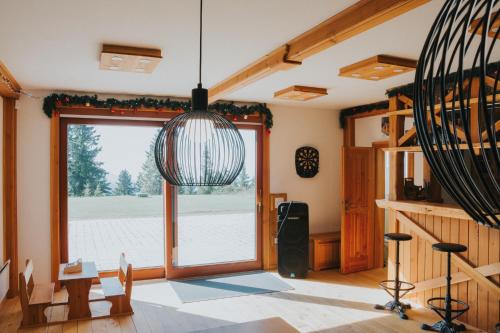 a room with a large window and a pendant light at Apartmaji Mara in Ribnica na Pohorju