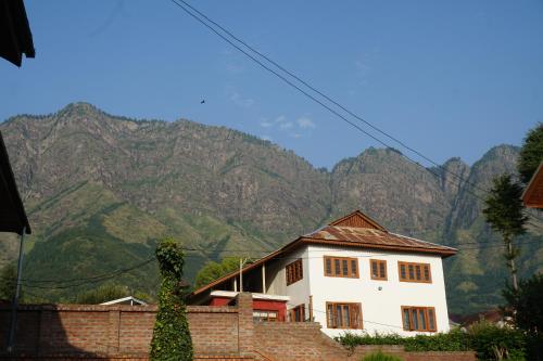 una casa blanca con montañas al fondo en Aubiz Villa, en Srinagar