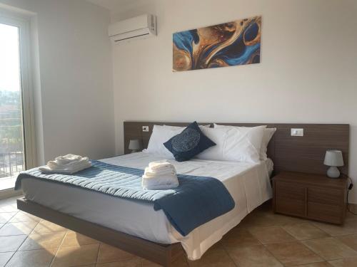 a bedroom with a large bed with two towels on it at Maison de Cheeramie - Tourist Apartments Tra Mare e Etna in Mascali