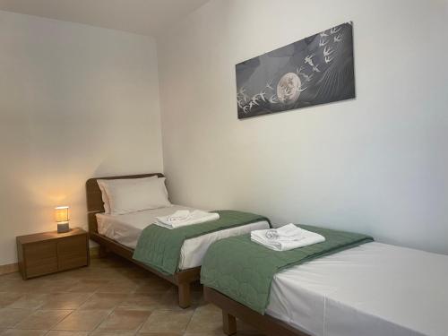 a room with two beds and a lamp and a picture at Maison de Cheeramie - Tourist Apartments Tra Mare e Etna in Mascali