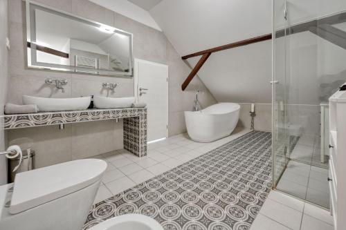 uma casa de banho com 2 lavatórios, uma banheira e um WC. em Apartments Old Town Gloria em Zagreb