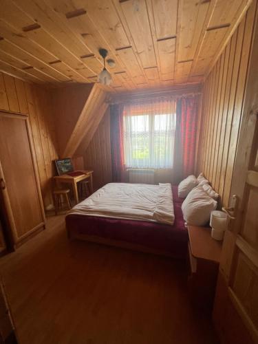 Bańska NiżnaにあるToporowy Dworekの木製の天井の客室のベッド1台分です。