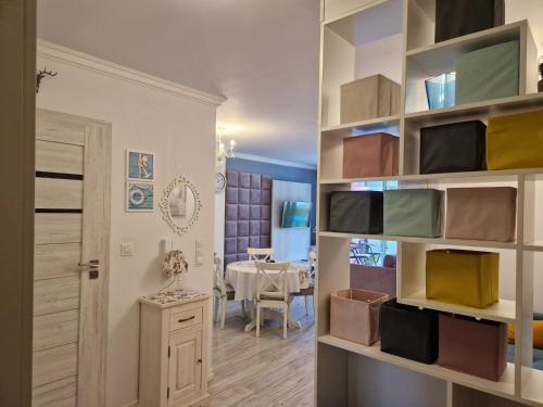 salon z dużą półką na książki i jadalnią w obiekcie Apartament Klaudynka w mieście Jantar