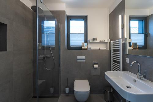 a bathroom with a shower and a toilet and a sink at Lee - Haus am See in Streu