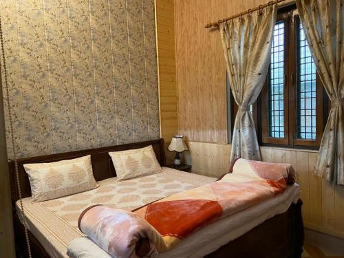 a bedroom with a bed in a room with a window at The Blessings in Bhowāli