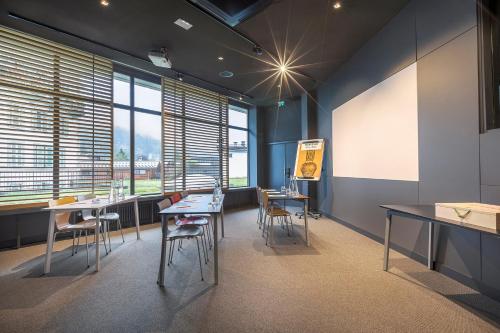a conference room with tables and chairs and windows at Alpina Eclectic Hotel in Chamonix-Mont-Blanc
