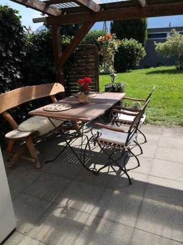 a wooden table and two chairs and a table and bench at Garten-Wohnung in Eschen