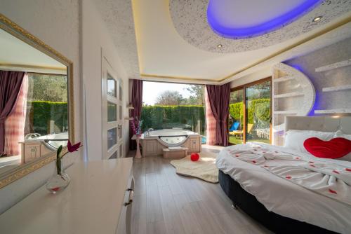 a bedroom with a bed and a bathroom with a tub at TERRA PİNE in Kayakoy