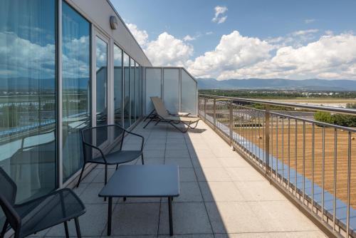a balcony with chairs and tables on a building at Hilton Geneva Hotel and Conference Centre in Geneva