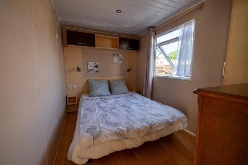 a small bedroom with a bed and a window at Mobilehome 4 personnes in Les Mathes