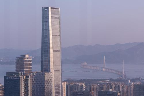 a tall building in a city with a bridge in the background at Shenzhen Marriott Hotel Nanshan in Shenzhen