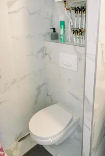 La salle de bains blanche est pourvue de toilettes et d'un mur en marbre blanc. dans l'établissement Studio cozy et moderne dans résidence à Nice, à Nice