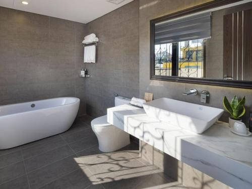 a bathroom with a tub and a sink and a toilet at Charming beauty hotel in Da Nang