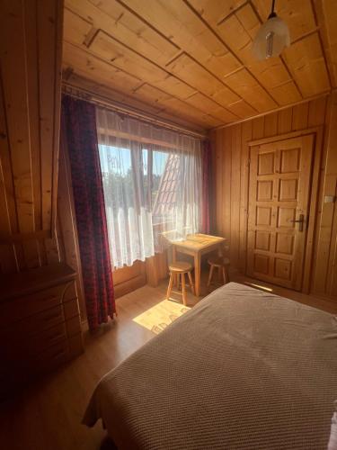 Bańska NiżnaにあるToporowy Dworekのベッドルーム1室(ベッド1台、窓、テーブル付)