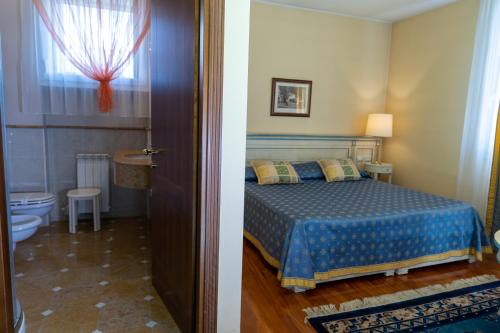a bedroom with a bed and a bathroom with a toilet at Le Muse Hotel in San Bonifacio