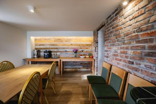 a dining room with a brick wall and a table and chairs at Dom do wynajęcia z tarasem i ogrodem Rokitek61 in Sandomierz