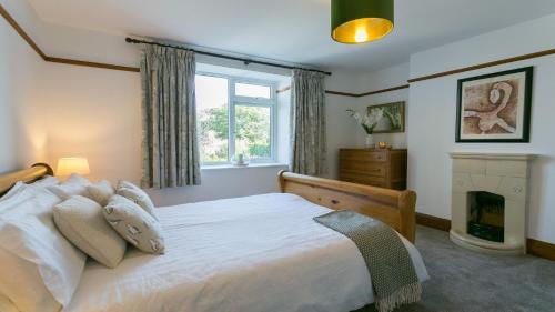 - une chambre avec un grand lit et une fenêtre dans l'établissement Gwelfor, à Nefyn