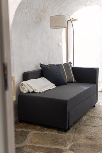 a black couch in a room with a lamp at Relais del Brigante in Settimo Vittone