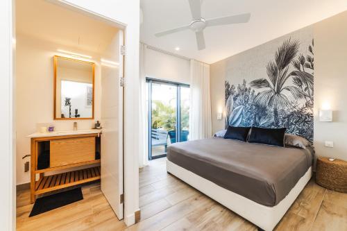 a bedroom with a bed and a mirror at Modern Penthouse - Nautilya BS1 in Grand Baie