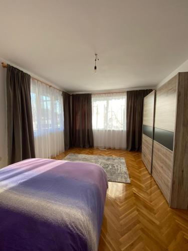 een slaapkamer met een bed en een houten vloer bij Gorgeous Two Bedroom Apartment in Silistra