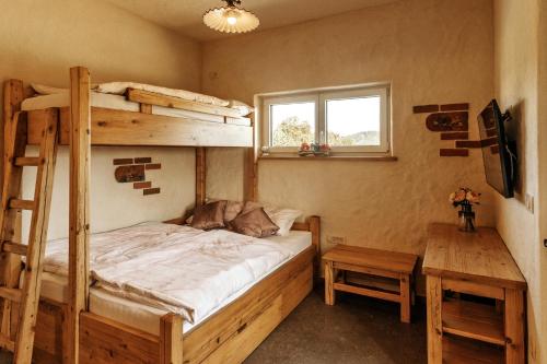 een slaapkamer met een stapelbed en een bureau bij Gostilnica Orle - Sleeping in the tower in Škofljica