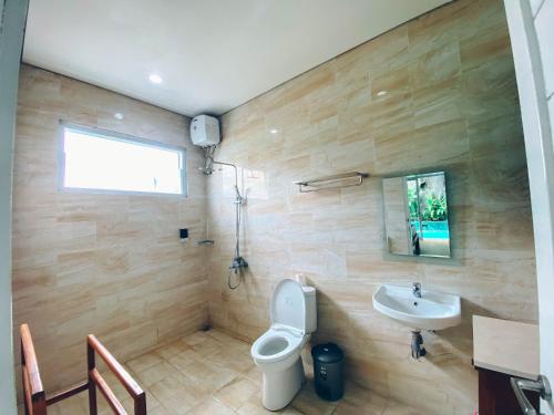 a bathroom with a toilet and a sink at The Green Home Bali in Denpasar