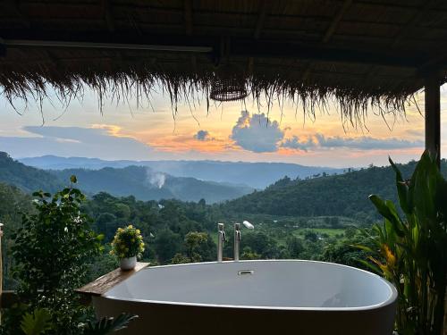 a bath tub in a resort with a mountain view at Wanna’s house in Ban Huai Khai