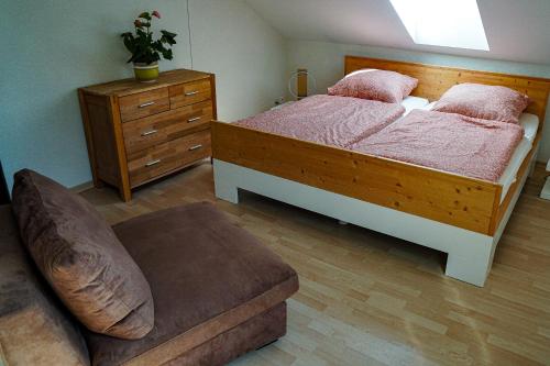 a bedroom with a bed and a chair and a dresser at Zug Zugersee Lake- and Mountainview House with charm in Zug