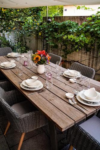uma mesa de madeira com pratos, copos e flores em Zug Zugersee Lake- and Mountainview House with charm em Zug