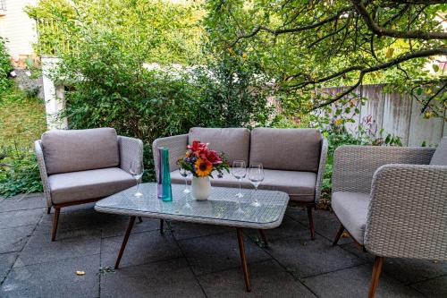 un tavolo con due sedie e un vaso con fiori di Zug Zugersee Lake- and Mountainview House with charm a Zugo