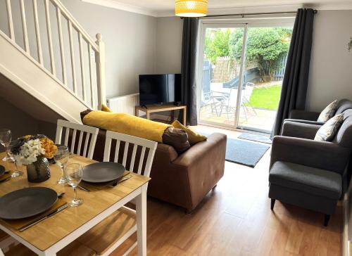 a living room with a table and a couch at Claygate Place - Modern 2 Bed House with Parking in Nottingham