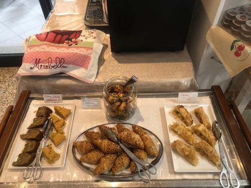 un buffet de comida en un mostrador con comida en Hotel Mirabella en Cattolica