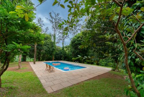 a swimming pool in the middle of a yard at Misty Heights by The Sanihara in Vayittiri
