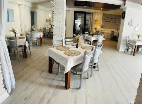 Piano في نوفي سوكز: غرفة طعام مع طاولات وكراسي بيضاء
