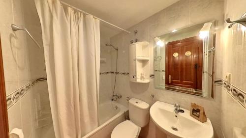 a white bathroom with a toilet and a sink at El Llano de Escarrilla - tucasaenlospirineos in Escarrilla