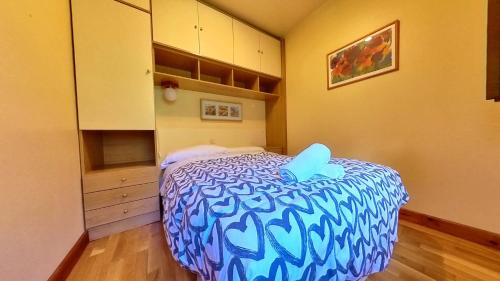 a small bedroom with a blue and white bed at El Llano de Escarrilla - tucasaenlospirineos in Escarrilla