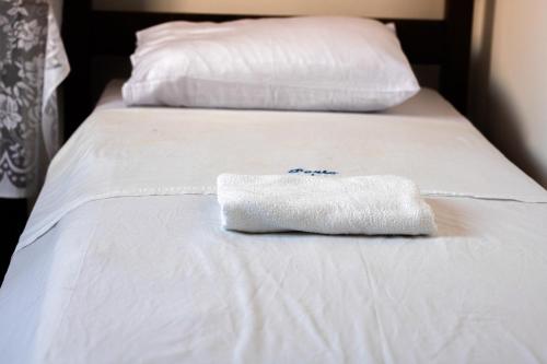 a white towel sitting on a white bed at Hotel Porto da Lua Belém in Belém
