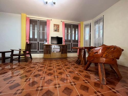 a living room with a wooden floor and a tv at Mae Somboon House in Lamai