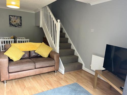 a living room with a couch and a tv and stairs at Claygate Place - Modern 2 Bed House with Parking in Nottingham