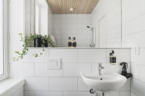 Heimen Hotel في بيرغِن: حمام أبيض مع حوض ومرآة