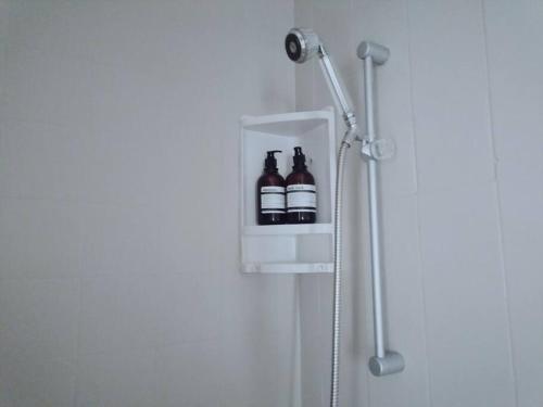 two bottles of beer sitting in a holder in a shower at Beachfront at 22 Settler's Sands in Port Alfred