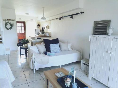 a living room with a white couch and a table at Beachfront at 22 Settler's Sands in Port Alfred